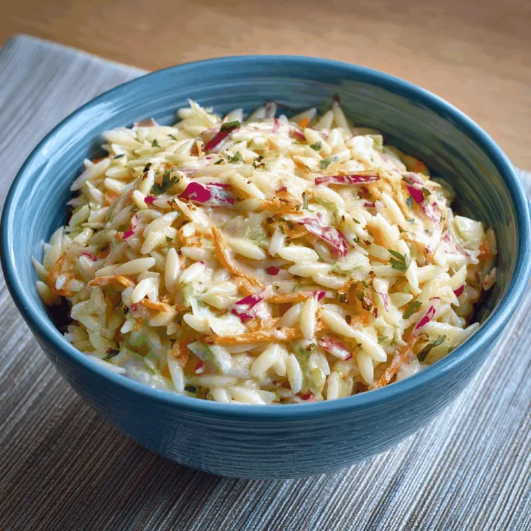 Close-up of a Coleslaw Orzo Salad with almonds, cranberries, and green onions.