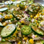 Close-up view of a vibrant Street Corn Creamy Cucumber Salad in a bowl.