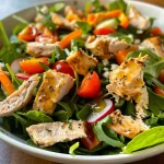 Close-up view of a colorful Honey Chicken Salad with mixed greens and diced vegetables.