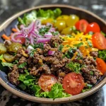 Close-up view of a burger salad bowl featuring lettuce, tomatoes, and ground beef.