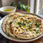 Close-up view of a golden-brown Chickpea Flour Naan on a rustic plate.