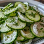 Close-up of a vibrant Cucumber Vinegar Salad featuring thinly sliced cucumbers and onions.