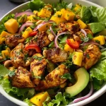 Close up of a colorful Spicy Mango Chicken Salad with diced mango and avocado.