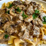 Close-up view of a creamy beef stroganoff served in a bowl, showcasing tender beef strips and mushrooms.