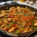 Close-up view of Garlic Chicken Lo Mein with colorful vegetables.