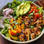 A vibrant Grilled Chili Lime Chicken Fajita Salad with sliced chicken, colorful bell peppers, and fresh avocado.