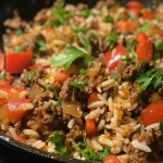 Juicy ground beef and rice skillet served in a pan with colorful vegetables.