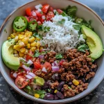 Close-up side view of a colorful Ground Beef Burrito Bowl filled with vibrant ingredients.