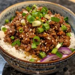 A close-up view of a Hot Honey Beef Bowl filled with ground beef, rice, and fresh vegetables.