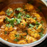 Close-up view of a bowl of Instant Pot Coconut Chicken Curry with garnished cilantro.
