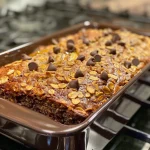 A slice of oatmeal banana bread with chocolate chips, showcasing a moist texture.