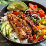 A close-up view of Chicken Fajita Rice Bowls with colorful vegetables and rice.