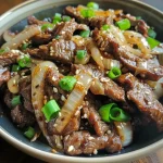 Close-up of a colorful stir-fry dish featuring sliced beef and onions.