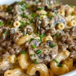 Close-up of creamy beef and mushroom macaroni in a bowl, showcasing juicy ground beef and sliced mushrooms.