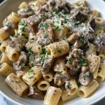 A close-up view of creamy beef and mushroom pasta featuring tender pieces of beef and mushrooms in a rich sauce.