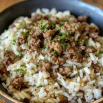 Close-up view of a bowl of Garlic Butter Beef and Rice, showcasing the rich ingredients.