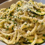 A close-up view of garlic butter noodles garnished with vegetables.