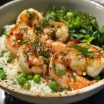 Close-up view of a garlic butter shrimp rice bowl with colorful vegetables.