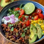 A close-up side view of juicy Ground Beef Taco Bowls filled with vibrant ingredients.