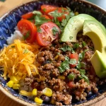 Close-up of a Ground Beef Taco Rice Bowl with colorful toppings.