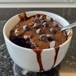 A close-up view of a Healthy Brownie in a Mug, showcasing its rich texture and chocolate chips.