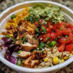 Close-up of a Mexican chicken burrito bowl with vibrant ingredients.