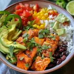 A colorful Salmon Burrito Bowl featuring salmon, rice, black beans, corn, and assorted toppings.