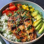 Close-up view of a vibrant Grilled Chicken Summer Rice Bowl featuring juicy chicken and fresh vegetables.