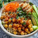 ['Close-up view of a Hot Honey Chickpea Bowl featuring chickpeas, vegetables, and rice.', 'Side view of a colorful Hot Honey Chickpea Bowl with honey-glazed chickpeas and fresh greens.', 'Detailed image of a Hot Honey Chickpea Bowl filled with chickpeas, brown rice, and chopped veggies.', 'Vibrant Hot Honey Chickpea Bowl showcasing honey, sriracha chickpeas, and assorted vegetables.']
