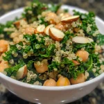 ['A vibrant kale and quinoa salad featuring colorful ingredients like pumpkin seeds and sliced almonds.', 'A close-up view of a fresh kale and quinoa salad drizzled with lemon dijon dressing, showcasing various textures.', 'A side view of a hearty kale and quinoa salad, highlighting the richness of ingredients including chickpeas and nuts.', 'A close-up image of a delicious kale and quinoa salad, garnished with lemon dijon dressing and various seeds.']