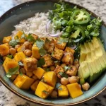 ['Close-up view of a vibrant Mango Chickpea Salad featuring cubed mangoes and chickpeas.', 'Colorful Mango Chickpea Salad displayed in a bowl, highlighting fresh ingredients and textures.', 'Juicy chunks of mango and cucumber in a chickpea salad, garnished with cilantro.', 'A side view of Mango Chickpea Salad, showcasing bright colors and fresh ingredients.']