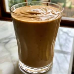 ['Side view of a creamy Caramel Apple Smoothie topped with whipped cream and caramel drizzle.', 'Close-up image of a green apple smoothie with caramel sauce, served in a glass with a straw.', 'Delicious Caramel Apple Smoothie showcasing the vibrant green color and whipped cream topping.', 'Frosted glass of caramel apple smoothie garnished with caramel sauce and a fresh apple slice.']