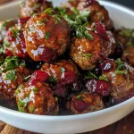['Side view of juicy cranberry meatballs served in a bowl.', 'Close-up photo of Christmas cranberry meatballs in a rich sauce.', 'Delicious meatballs coated in cranberry sauce, presented on a festive table.', 'A vibrant dish of Christmas cranberry meatballs glistening under natural light.']