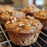 ['Close-up side view of a freshly baked cinnamon roll protein muffin with a golden-brown top.', 'Juicy cinnamon roll protein muffin highlighting its moist texture and sprinkled nuts.', 'Side view of a cinnamon roll protein muffin showcasing its rich cinnamon color and raisins.', 'Delicious-looking protein muffin with a cinnamon swirl, nuts, and a soft interior.']