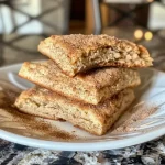 ['Close-up side view of golden brown cinnamon scones with a flaky texture.', 'A deliciously baked cinnamon scone with a sprinkle of cinnamon sugar on top.', 'Juicy cinnamon scones arranged on a plate, showcasing their soft and crumbly interior.', 'A side view of cinnamon scones highlighting their rich, creamy topping and golden crust.']