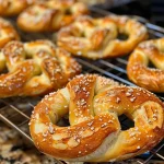 ['Close-up view of golden brown cottage cheese soft pretzels on a wooden surface.', 'Side view of freshly baked cottage cheese soft pretzels with a shiny glaze and salt on top.', 'Juicy cottage cheese soft pretzels arranged artfully on a plate, showcasing their texture.', 'Delicious, fluffy cottage cheese soft pretzels captured in vibrant detail against a rustic backdrop.']