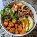['Close-up of a vibrant Harvest Sweet Potato Quinoa Bowl with a variety of colorful ingredients.', 'Side view of a nutritious Harvest Sweet Potato Quinoa Bowl showcasing diced sweet potatoes, quinoa, and greens.', 'Detailed view of a Harvest Sweet Potato Quinoa Bowl with sweet potatoes, baby greens, and garnishes.', 'Close-up angle of a healthy Harvest Sweet Potato Quinoa Bowl filled with colorful vegetables and nuts.']