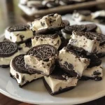 ['Close-up of No-Bake Oreo Cheesecake Bites with a smooth texture.', 'Side view of creamy Oreo cheesecake bites garnished with cookie pieces.', 'Delicious No-Bake Oreo Cheesecake Bites arranged on a plate.', 'Healthy dessert bites made with Oreo thins and cream cheese.']