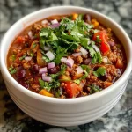 ['Close-up view of a bowl of hearty vegan chorizo chili with colorful ingredients.', 'Juicy vegan chorizo chili showcased in a side view, highlighting fresh vegetables and herbs.', 'A vibrant bowl of vegan chorizo chili, featuring diced onions, peppers, and cilantro.', 'Side angle of a steaming bowl of vegan chorizo chili, decorated with cilantro and served with tortilla chips.']