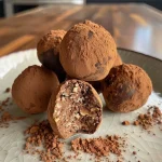 ['Close-up of rich, dark chocolate coffee truffles with a glossy finish.', 'Side view of delectable high-protein coffee truffles, showcasing their texture.', 'Juicy coffee truffles coated in cocoa powder, displayed on a neutral surface.', 'Gourmet high-protein coffee truffles arranged invitingly, with nuts sprinkled around.']