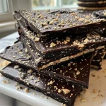 ['Close-up view of Halloween-themed chocolate bark topped with Oreo pieces and a peanut butter spread.', 'Side angle of high protein, low sugar chocolate bark featuring a Halloween design with festive toppings.', 'Detailed image of decadent chocolate bark showcasing chunks of Oreos and rich peanut butter spread.', 'Mouthwatering display of healthy Halloween chocolate bark, emphasizing its high protein and low sugar content.']