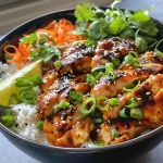 ['A close-up of a hot maple chicken bowl with rice and sauce.', 'Juicy pieces of chicken in a maple chili sauce on a bed of rice.', 'A side view of a delicious chicken bowl garnished with cilantro and lime.', 'Bowl filled with chicken, rice, and vibrant toppings, showcasing its freshness.']