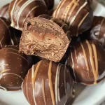 ['Close-up side view of a KitKat Truffle, showcasing its smooth chocolate exterior and visible crispy layers.', 'A mouthwatering KitKat Truffle captured from the side, highlighting its rich chocolate coating and inner filling.', 'Side angle photograph of a KitKat Truffle, featuring the chocolate shell and layered crunchiness.', 'Detailed side view of a decadent KitKat Truffle, revealing its glossy chocolate surface and layers inside.']