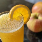 ['Close-up of a vibrant Non Alcoholic Apple Cider Mimosa in a glass.', 'Side view of a glass filled with sparkling apple cider mimosa with orange juice.', 'Refreshing Non Alcoholic Apple Cider Mimosa garnished elegantly.', 'Juicy apple cider mimosa with a bubbly texture in a clear glass.']