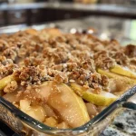 ['Close-up of a warm, golden-brown pear crumble in a baking dish.', 'Side view of a pear crumble with a flaky topping, showcasing juicy pear slices.', 'Detail of baked Old Fashioned Pear Crumble with a crispy, buttery crust.', 'Freshly baked pear crumble, highlighting the sweet fruit filling and crunchy topping.']