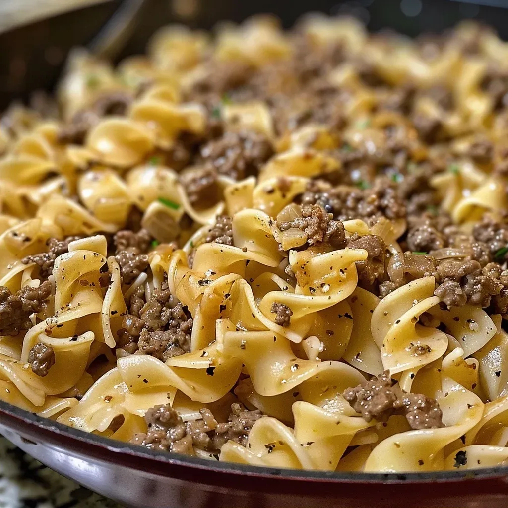 ['A close-up of a plate of One-Pan Beef and Noodles showcasing juicy ground beef and egg noodles.', 'Side view of a serving of One-Pan Beef and Noodles highlighting the creamy sauce and garnished with herbs.', 'A delicious bowl of One-Pan Beef and Noodles featuring tender beef, noodles, and a rich broth.', 'A vibrant dish of One-Pan Beef and Noodles with a mixture of beef, noodles, and spices glistening.']