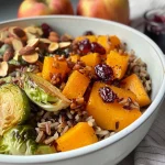 ['A close-up side view of a colorful Wild Rice Harvest Bowl featuring butternut squash, brussels sprouts, apples, and cheese.', 'An appetizing Wild Rice Harvest Bowl with vibrant ingredients like butternut squash and cranberries, set against a neutral background.', 'A detailed view of a Wild Rice Harvest Bowl filled with grains, fresh vegetables, and topped with fig balsamic vinaigrette.', 'A hearty Wild Rice Harvest Bowl showcasing a medley of roasted vegetables, nuts, and cheese, served in a rustic bowl.']